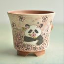 Ceramic planter with panda design on a light background