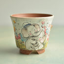 Ceramic cup with a cartoon elephant design on a light background