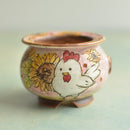 Small ceramic pot with a chicken and sunflower design on a light background