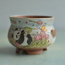 Ceramic bowl with panda and floral design on a light gray background